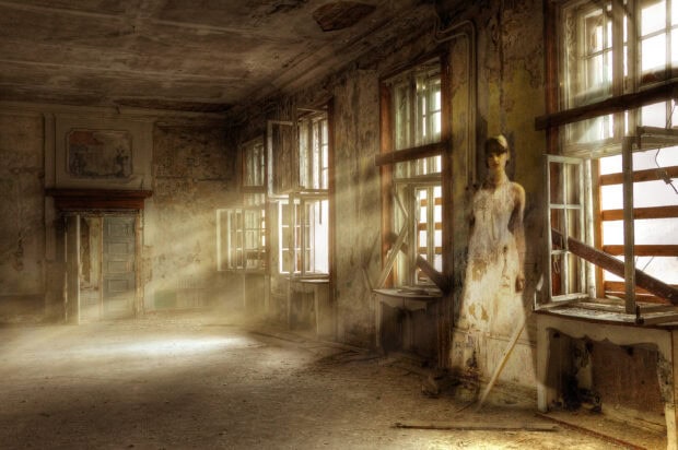Abandoned room with gothic art featuring a ghostly woman in a white dress
