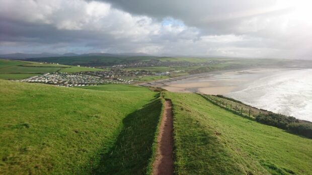 Path along green hills in Gower Peninsula landscape