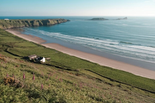 A scenic view of the peninsula coastline with cliffs and waves at Gower Peninsula