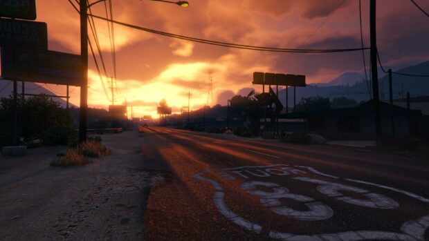 A sunset view of Route 68 road in Grand Theft Auto 5 with warm glowing sky and distant mountains
