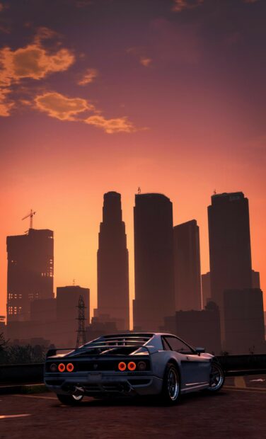 A sports car from Grand Theft Auto 5 parked with a city skyline at sunset in the background