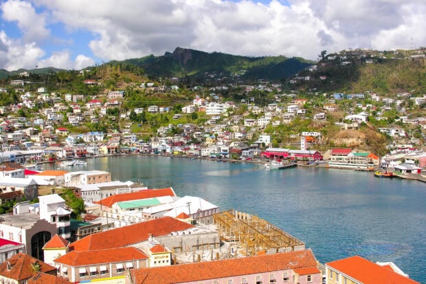 Panoramic view of Grenada town with hillside homes and calm sea bay