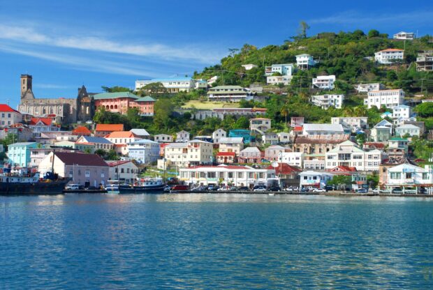Colorful hillside townscape of Grenada with clear blue water and bright sky