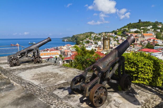 Historic cannons overlooking Grenada city and blue sea under a clear sky