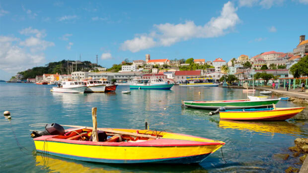 Colorful boats docked in the harbor of Grenada town under a clear blue sky