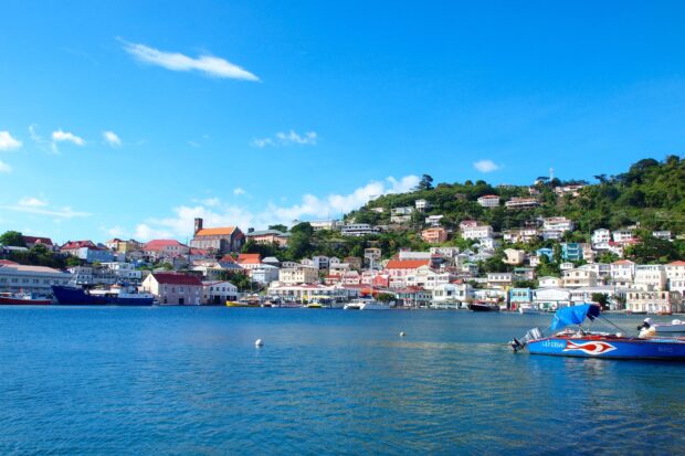 Colorful Grenada townscape with calm sea and boats under blue sky