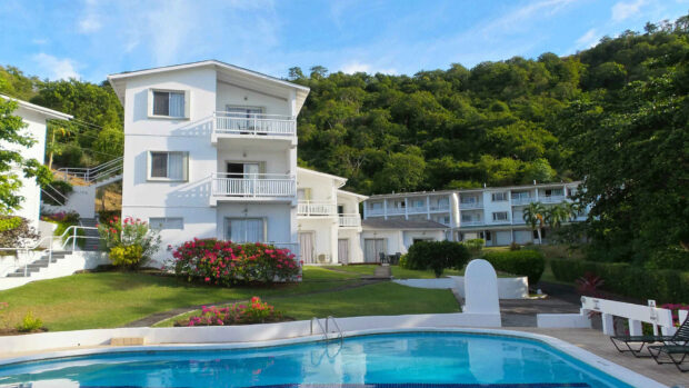 White buildings with pool and lush greenery in Grenada resort area