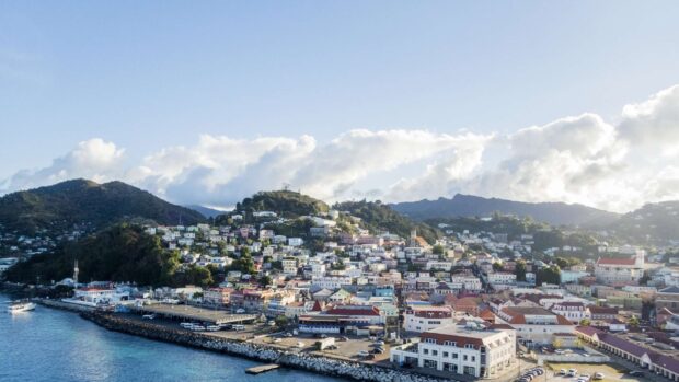 A beautiful view of Grenada cityscape with hills and waterfront under a blue sky