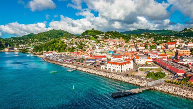 A vibrant Grenada cityscape with colorful buildings along the clear blue coastline