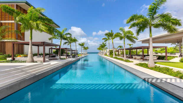 Tropical resort scene with palm trees along a long pool in Grenada