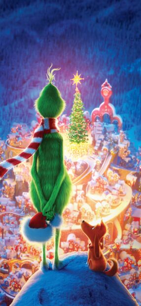 The Grinch and his dog looking at a glowing Christmas tree in the snowy town at night