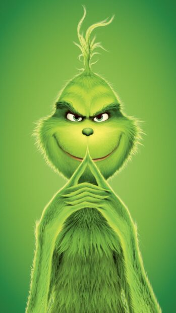 A mischievous Grinch character with green fur and a sly smile planning something
