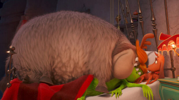 The Grinch lying in bed with a large furry creature and an orange dog nearby