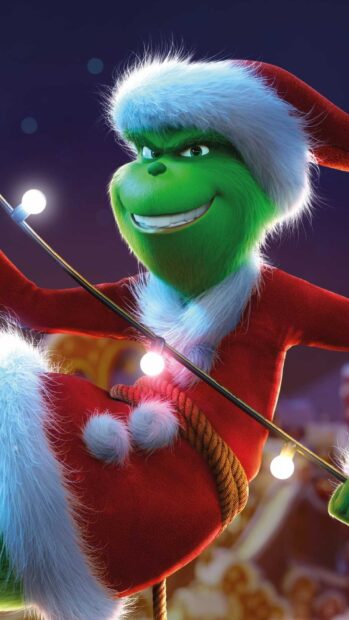 The Grinch wearing a Santa suit and holding Christmas lights with a mischievous smile
