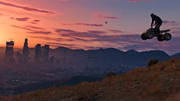 A gta V character jumping a quad bike over a hill during sunset with the city skyline in the background