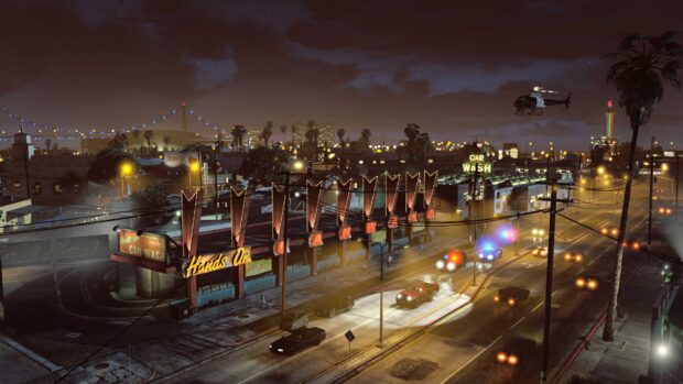 Nighttime cityscape in gta v with police chase near a car wash and helicopter overhead