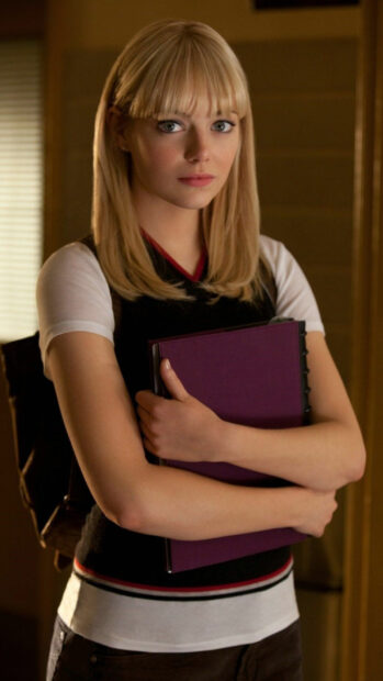 Gwen Stacy holding a purple binder with a serious expression in an indoor setting