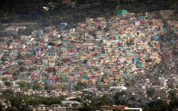 Colorful buildings densely packed on a hillside in Haiti cityscape