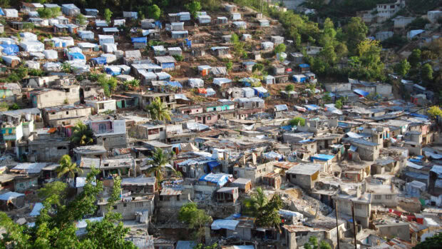 Haitian community with densely packed houses on hillside in tropical environment
