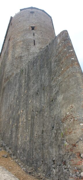 Old Haitian stone fortress wall with weathered bricks and small windows
