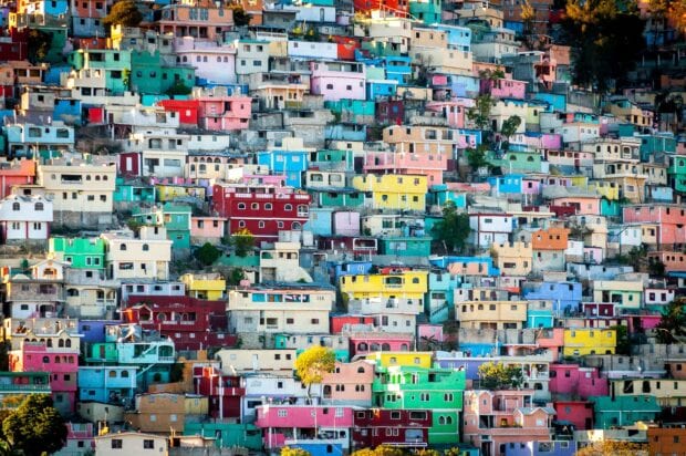 Colorful buildings on a hillside in Haiti create a vibrant urban landscape in bright hues