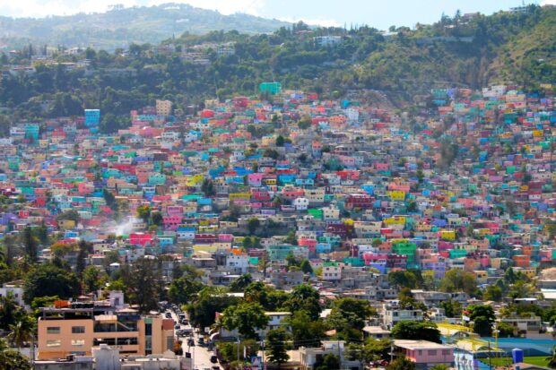 Colorful houses densely packed on a hillside in Haiti cityscape during daylight