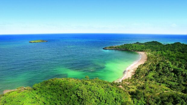 A scenic view of Haiti coastline with lush green forests and clear blue waters