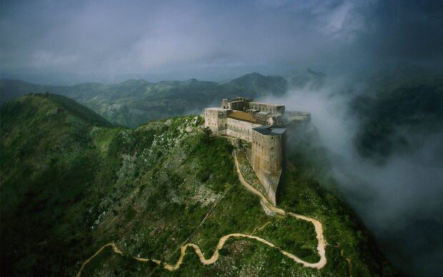 Ancient Haiti fortress surrounded by winding mountain paths and misty clouds
