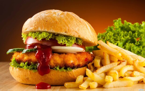 Crispy chicken sandwich with lettuce tomato and ketchup served with french fries
