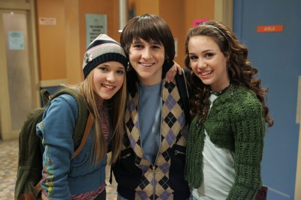 Young friends smiling together in a school hallway with Hannah Montana style clothing