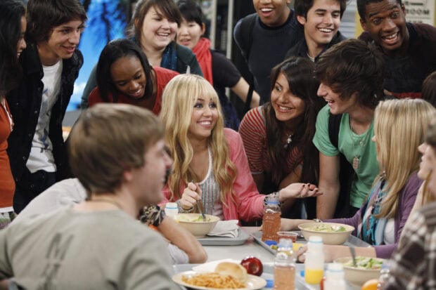 Hannah Montana smiling and talking with friends in a school cafeteria scene