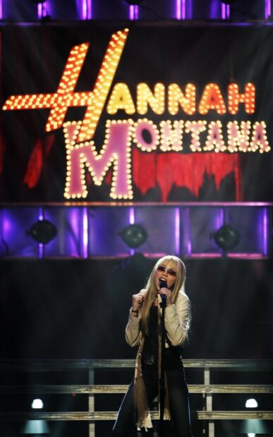 Hannah Montana singing on stage with a microphone during a live performance