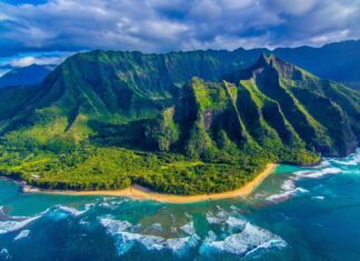 Aerial view of lush Hawaiian Islands with green cliffs and turquoise ocean waves