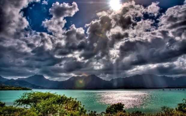 Dramatic clouds over the Hawaiian Islands mountains and turquoise ocean water