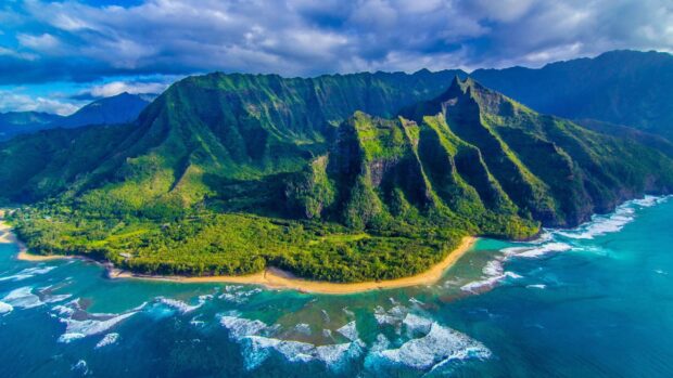 Aerial view of lush Hawaiian Islands with green cliffs and turquoise ocean waves