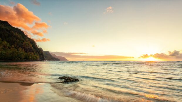 Serene coastline of Hawaiian Islands with sunset and tropical hills