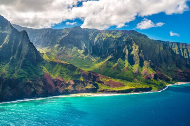 Aerial View Of Hawaiian Islands with Lush Mountains and Coastal Shoreline under Blue Sky