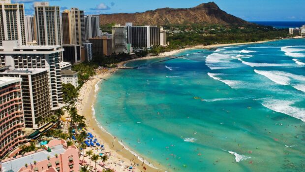 Waikiki Beach with Diamond Head volcano and surfers in Hawaiian Islands