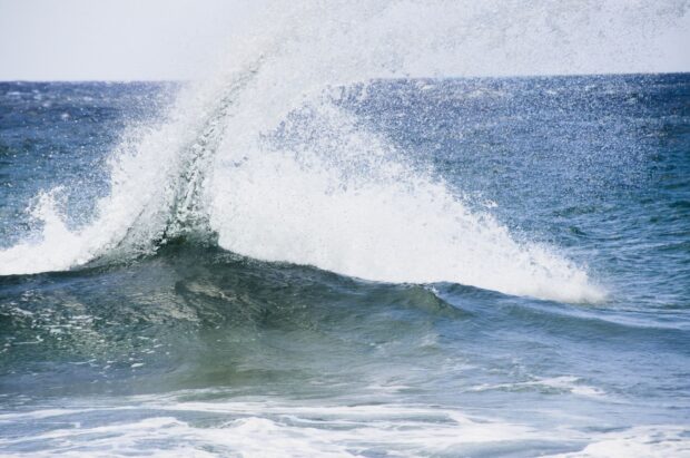 Ocean wave crashing with clear blue sea in Hawaii