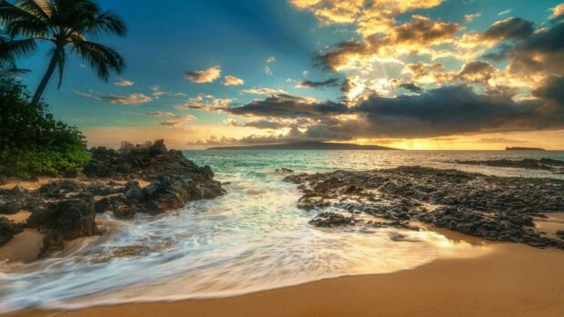Rocky Hawaiian coast with ocean waves and sunset clouds