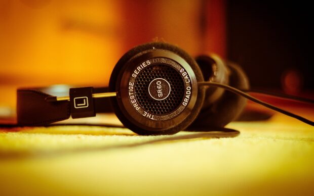 Close up of headphones from the prestige series lying on a surface with warm lighting