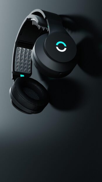 Black headphones with soft cushions and a modern design placed on a dark surface