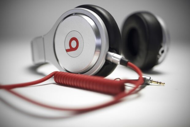 Close up of headphones with red cable on a white surface showcasing headphones design