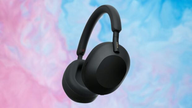 Black headphones with soft ear cushions floating on colorful pastel background