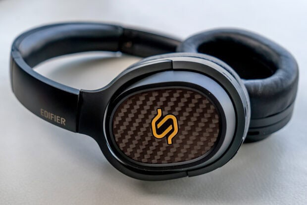 Black headphones with carbon fiber detail and a yellow logo on the ear cup