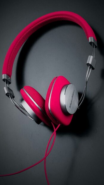 Red headphones with metal accents on a dark surface featuring Bowers and Wilkins logo