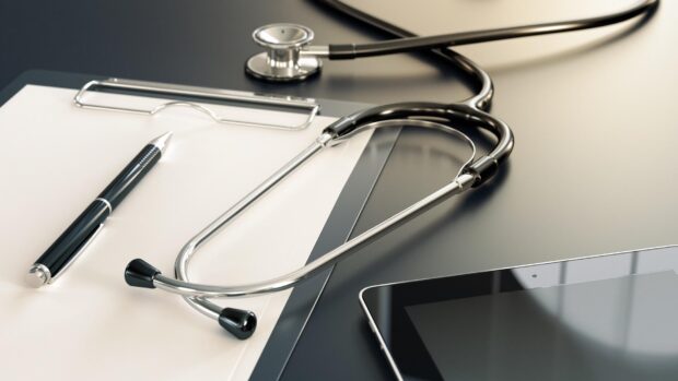 Stethoscope and pen on clipboard symbolizing health on a desk