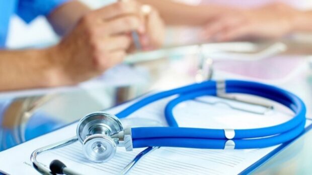 A blue stethoscope resting on a medical clipboard symbolizing health care