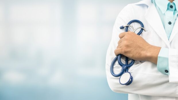 A medical professional holding a stethoscope representing health care and wellness