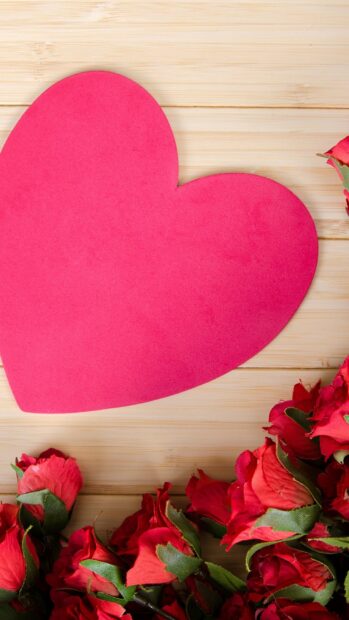 Red heart shape with roses on wooden background in hearts and flowers design